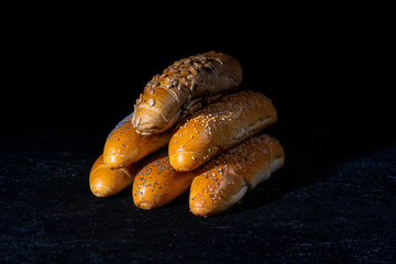 Fresh rolls on dark background. Poppy seed roll and sesame seed roll. Typical popular czech breakfast rolls or buns.