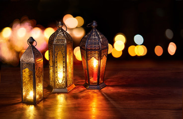 Ramadan lanterns on the table. Dark background with street light and bokehs. Beautiful Greeting...