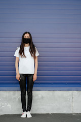 Woman wearing face mask because of Air pollution or virus epidemic in the city. Оn a blue background. Corona virus concept.