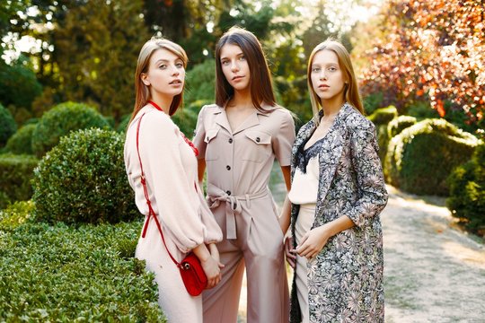 three gorgeous young women posing outdoors 