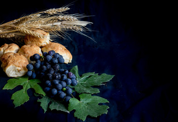 wheat grapes bread and crown of thorns on black background as a symbol of Christianity