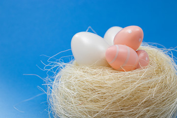 Happy Easter - Easter eggs in a nest against blue background