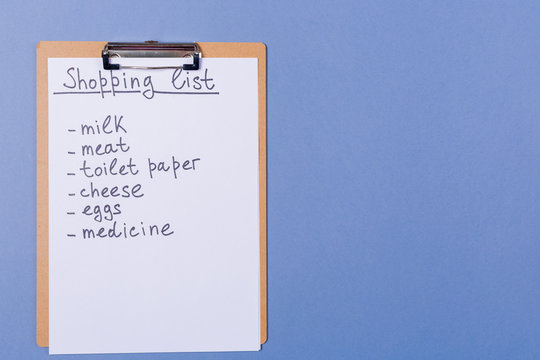 Handwriting Shopping list of products on clipboard. Free copy space. Ready for shopping. Internet shopping. Distant shopping concept. 
