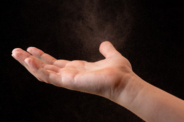 spraying antiseptics on hands for disinfection on a black background