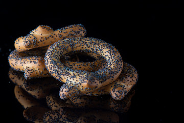 Bagels with poppy seeds on a dark background. Photographed close-up.