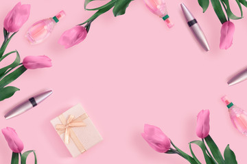 Beautiful pink tulips with  gold gift box,  cosmetics on  pink paper background.