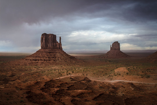 An incoming storm in the background of the scenic view of The Mittens and Merrick Butte from John Wayne's Point in the Oljato Navajo Monument Valley, Arizona, USA
