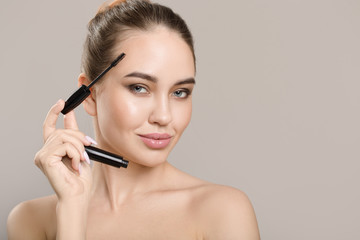 Fototapeta premium woman doing her makeup eyelashes black mascara