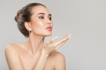 beautiful young woman with bare shoulders on a gray background. Skin and face care concept. spa