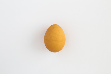 Ugly food. Ugly brown  chicken egg in the center of the white background. Top view. Copy space.