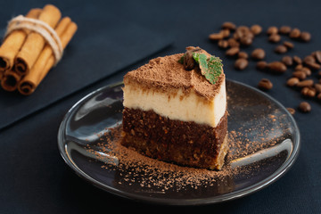 Tiramisu on a beige plate. Coffee with cinnamon. Raw dessert	
