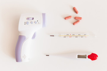 Pills and thermometer on a blue background, the concept of a coronavirus or flu epidemic. Prevention of the Covid-19 pandemic virus. Quarantine. Biological supplements, vitamins, medicines for health.