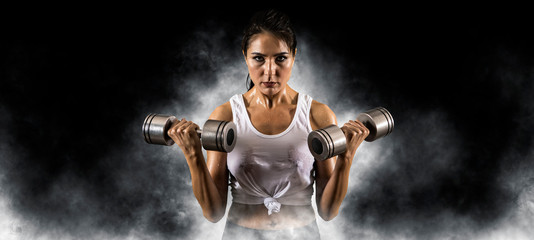 Fototapeta na wymiar Woman working out with dumbbell