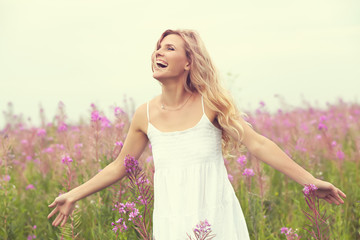 outdoor portrait of a beautiful middle aged blonde woman. attractive sexy girl in a field with flowers. - 336139993