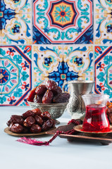 Assorted dried dates or kurma served on a vintage plates and tea.