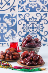 Assorted dried dates or kurma served on a vintage plates and tea.