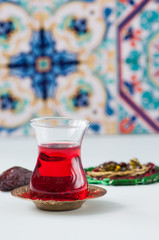 Turkish tea in a glass, muslim beads on a white background.