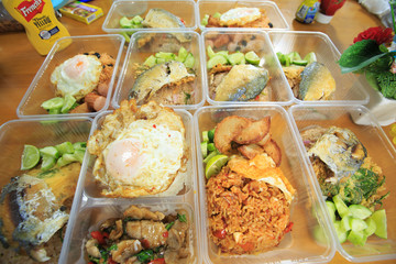 Several American fried rice boxes in a plastic wave box on a wooden table