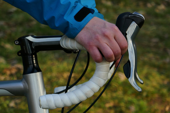 woman on a gravel bike, hand pushes the brakes