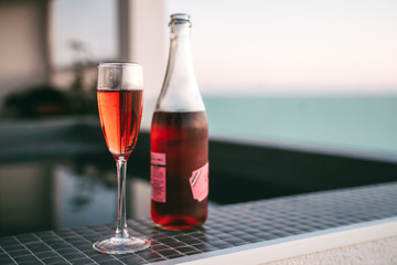 Classy rose wine glass and bottle on poolside