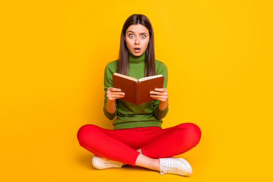 Photo of funny pretty beautiful lady sit floor holding school literature book reading intrigue thriller story wear casual green jumper red trousers isolated yellow color background