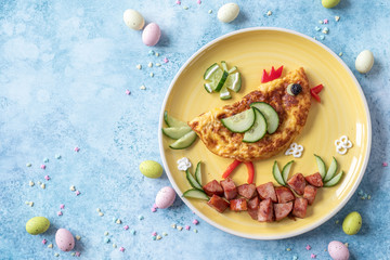 Fototapeta na wymiar Funny chick egg omelette with ham vegetables for kids breakfast