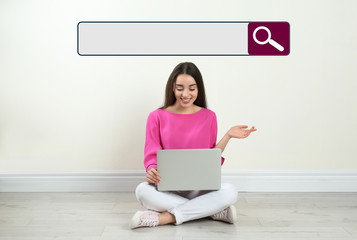 Search bar of internet browser and woman with laptop sitting on floor near light wall indoors