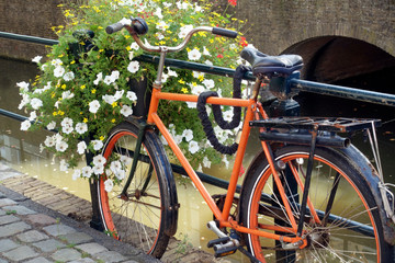 Fototapeta na wymiar Old-fashioned Dutch city bike near a bridge over canal