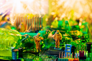 The ecologists or technicians cleaning toxic or radioactive waste on motherboard.  Environment,...