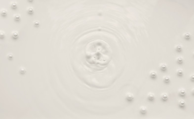 Splash of milk with pearls on a white background.
