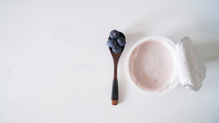 Blueberry yogurt on a white wooden table. Fresh yogurt. Healthy eating concept. High Resolution Product. View from above
