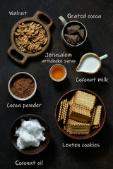Ingredients for cooking vegetarian chocolate salami with product names on dark background. Flat lay