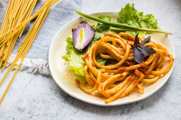 Italian traditional pasta, classical spaghetti dish. Vegan meal, vegetarian food. Ingredients, vegetables, salad leaves.