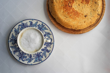 Spanish potato omelette next to a cup of cappuccino. Typical Spanish breakfast at a bar. Top View. Served on top of a wooden board. Space for text. 