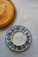 Spanish potato omelette next to a cup of cappuccino. Typical Spanish breakfast at a bar. Top View. Served on top of a wooden board. Space for text. 