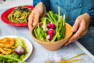Fresh organic vegetables, radish, salad leaves, onion sprouts. Healthy detox  vegan dieting food. Woman hands