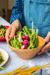 Fresh organic vegetables, radish, salad leaves, onion sprouts. Healthy detox  vegan dieting food. Woman hands