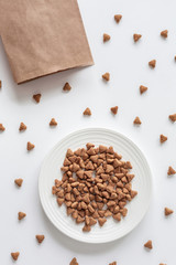 Background of cat dry food and paper packaging. Domestic kitty care. Natural backdrop