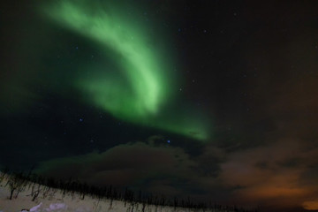 Fototapeta na wymiar L'aurora boreale danza nella notte, oltre il circolo polare artico