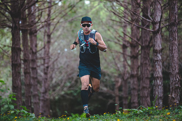 A man Runner of Trail and athlete's feet wearing sports shoes for trail running in the forest
