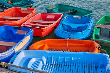 Fototapeta na wymiar Collection of Coloured Dinghies tied up to a pontoon