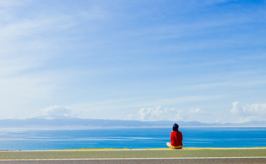Obraz premium Young girl looking at horizon of Sayram Lake, China