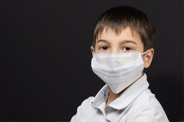boy in a medical mask against a dark background