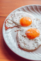 Fried eggs with salt and pepper on a plate