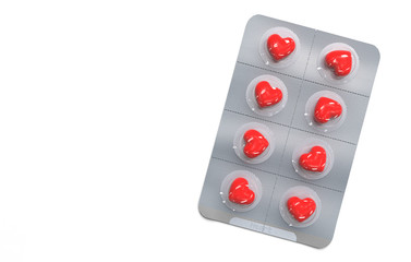 Red pills in the shape of a heart in a blister. Pill packaging on a white background. Creative concept. Copy space. 3D render illustration.
