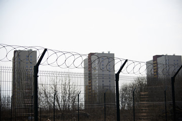 Obraz premium Residential buildings and a kindergarten surrounded by barbed wire