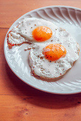 Fried eggs with salt and pepper on a plate