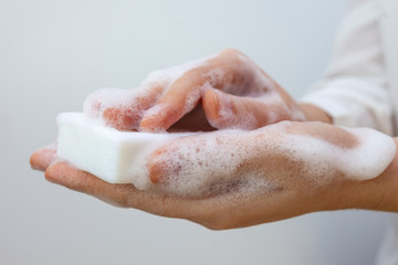 Fototapeta premium The girl washes her hands with a white bar of soap