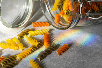 Concept explosion of colourful pasta on rainbow light.
