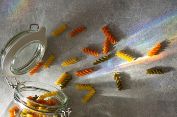 Obraz na płótnie Canvas Concept explosion of colourful pasta on rainbow light.